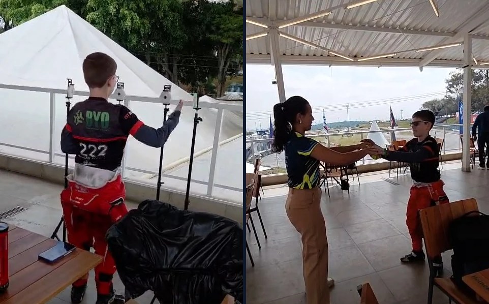 Nicolas Souza de costas, com o macacão número 222, diante de luzes de treino montadas em tripés; Nicolas Souza de mãos dadas com uma adulta, em uma área coberta ao lado da pista